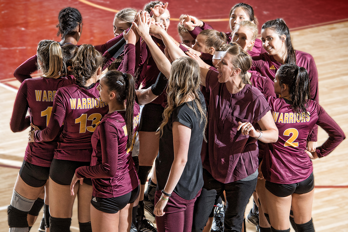 Women's Volleyball team huddled together.
